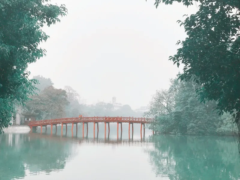 The red Huc Bridge over Hoan Kiem Lake in Hanoi on a misty morning